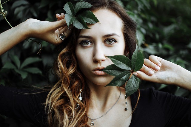 A-women-posing-with-green-leaves-on-face